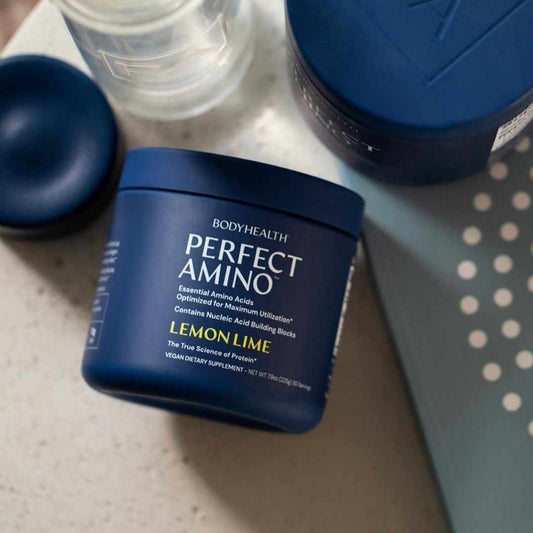 BodyHealth Perfect Amino supplement container with lemon lime flavor on a surface.